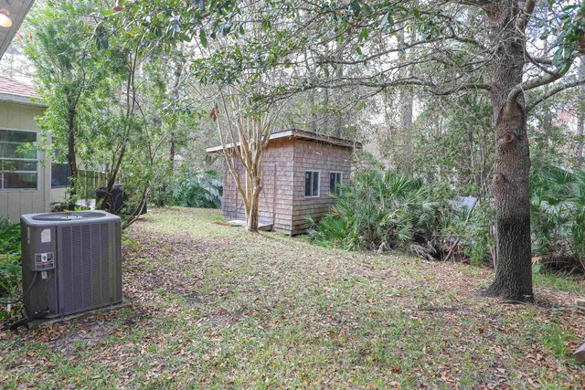 a view of a house with a yard and large tree