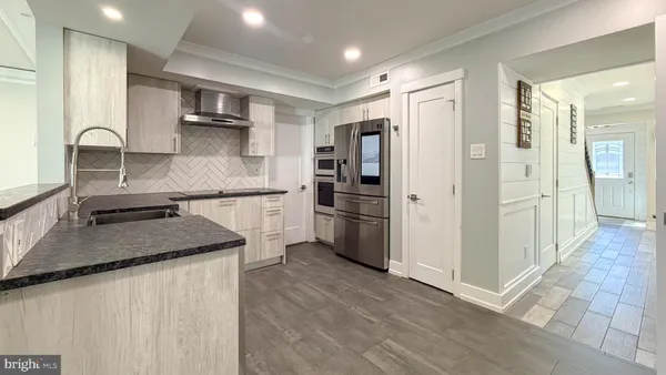 a kitchen with white cabinets and a refrigerator