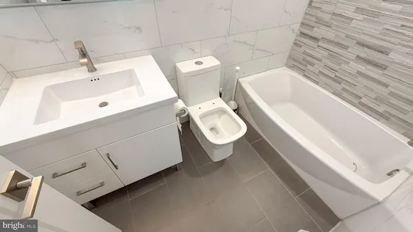 a white toilet sitting next to a bathroom sink