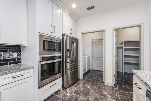 a kitchen with stainless steel appliances granite countertop a stove a sink and a refrigerator