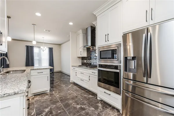 a kitchen with stainless steel appliances granite countertop a stove and a microwave