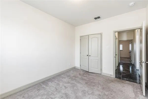 a bathroom with a granite countertop sink toilet and mirror