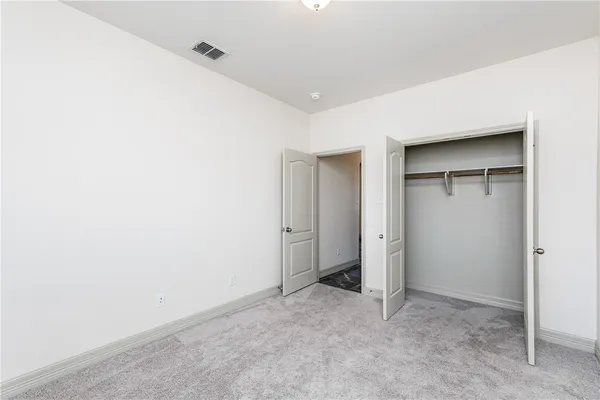 a bathroom with a granite countertop toilet sink and mirror
