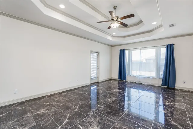 a view of an empty room with window and chandelier