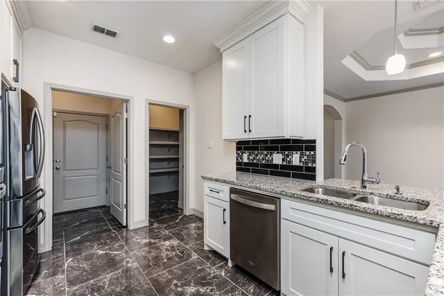 a kitchen with white cabinets and stainless steel appliances