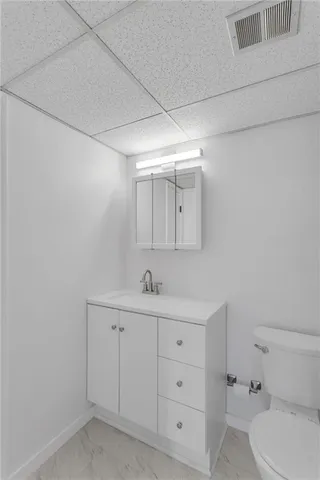 a bathroom with a toilet a sink a vanity and mirror