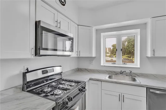 a kitchen with cabinets appliances and a sink