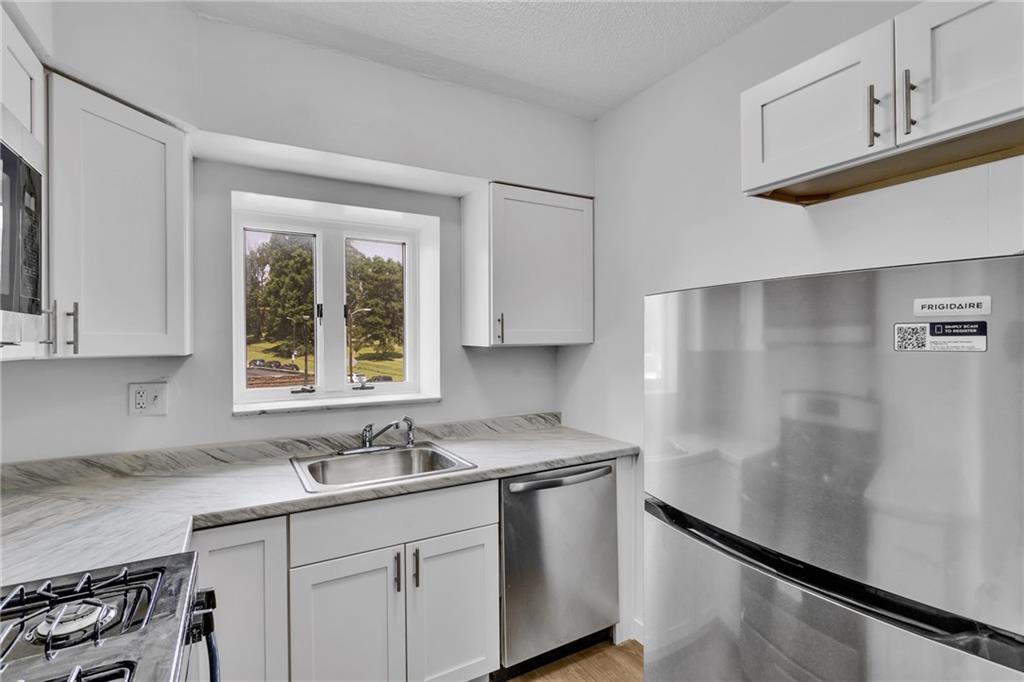 520 Washington Road, Unit 301 Pittsburgh, PA 15228 - Photo 9 of 20 a kitchen with stainless steel appliances granite countertop a sink window and cabinets