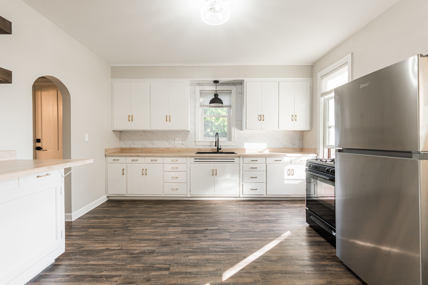 113 Elm Street, Unit B Elgin, IL 60123 - Photo 9 of 22 a kitchen with stainless steel appliances granite countertop a refrigerator and white cabinets with wooden floors