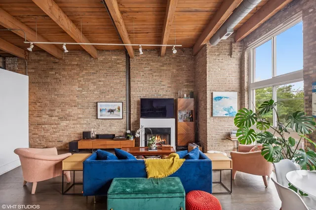 a living room with furniture a fireplace and a potted plant