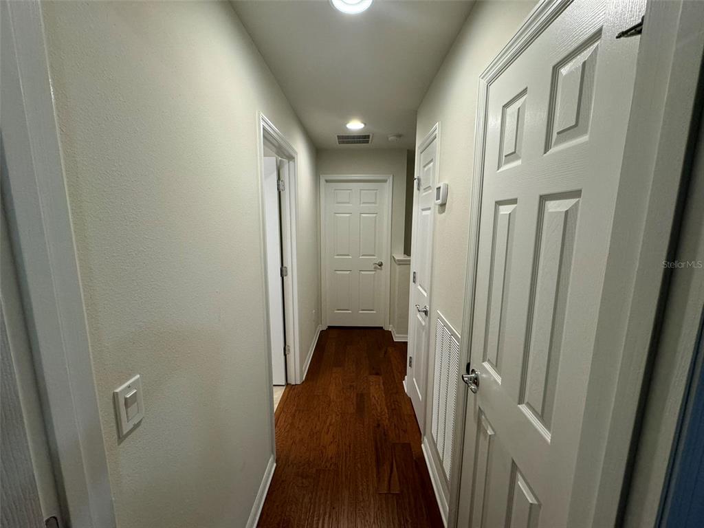 12124 Talitha Lane Orlando, FL 32827 - Photo 11 of 30 a view of a hallway with wooden floor and a bathroom