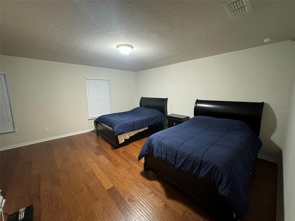 12124 Talitha Lane Orlando, FL 32827 - Photo 12 of 30 a bedroom with two bed and a night stand