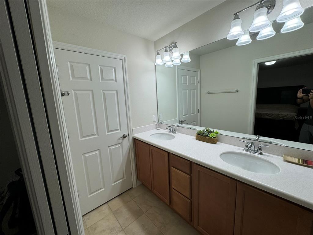 12124 Talitha Lane Orlando, FL 32827 - Photo 23 of 30 a bathroom with a double vanity sink and a mirror