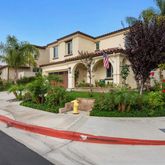 a front view of a house with a yard and potted plants
