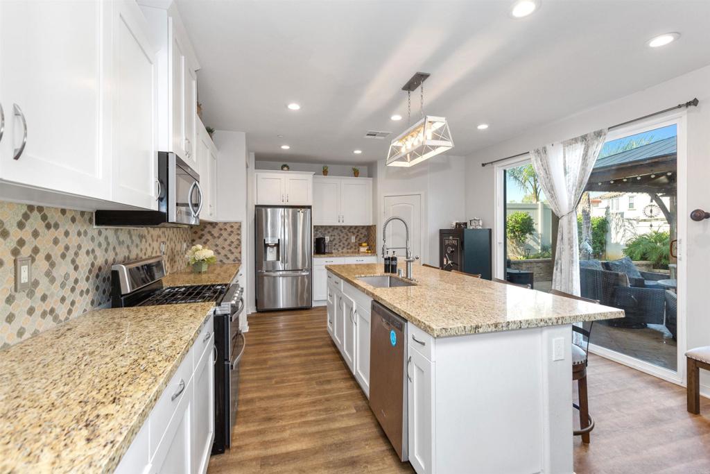 4260 C. Del Vista Oceanside, CA 92057 - Photo 13 of 38 a large kitchen with kitchen island a large counter top space a sink stainless steel appliances and cabinets