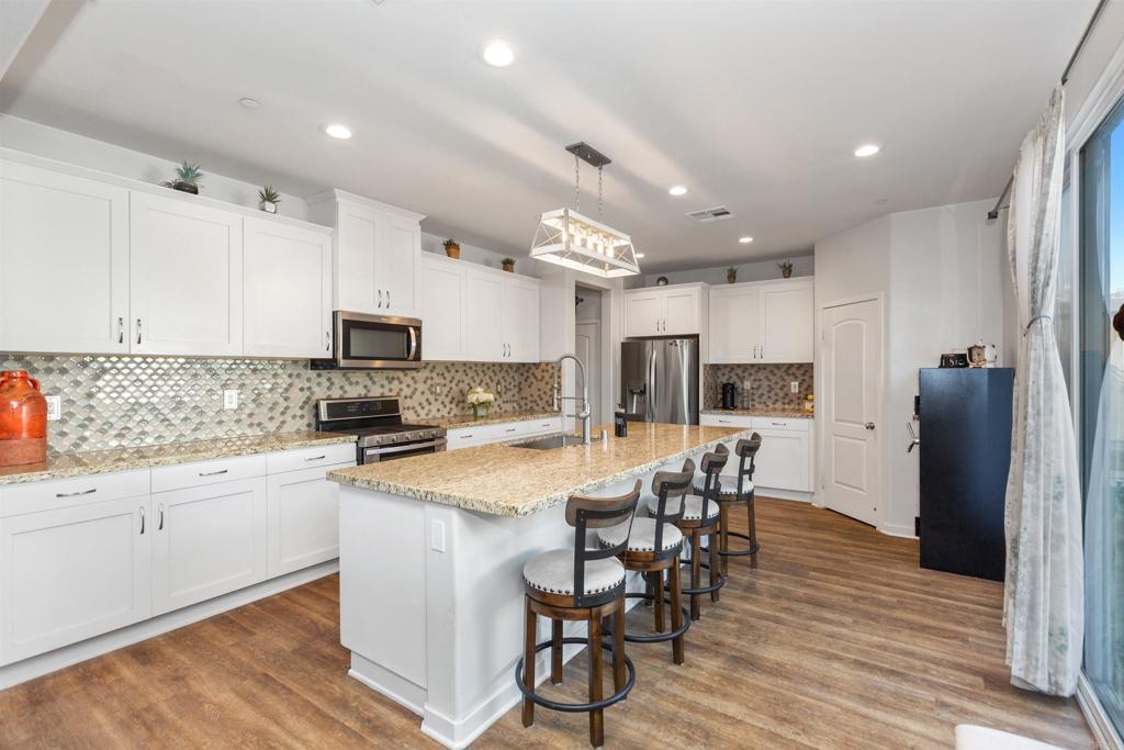 4260 C. Del Vista Oceanside, CA 92057 - Photo 16 of 38 a kitchen with stainless steel appliances a refrigerator a stove top oven and a center island