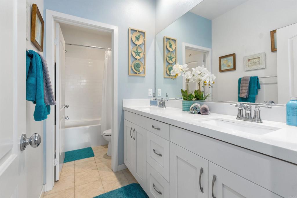 4260 C. Del Vista Oceanside, CA 92057 - Photo 24 of 38 a bathroom with a double vanity sink a mirror a shower and a bathroom