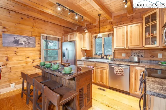 a kitchen with granite countertop a sink a counter space stainless steel appliances cabinets and a counter top space