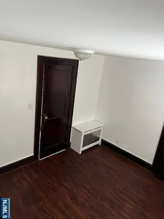 an empty room with wooden floor and white walls