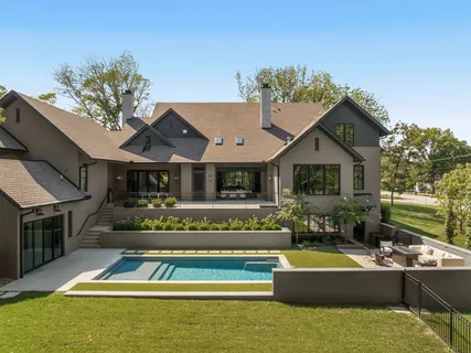 a view of house with swimming pool outdoor seating and a garden