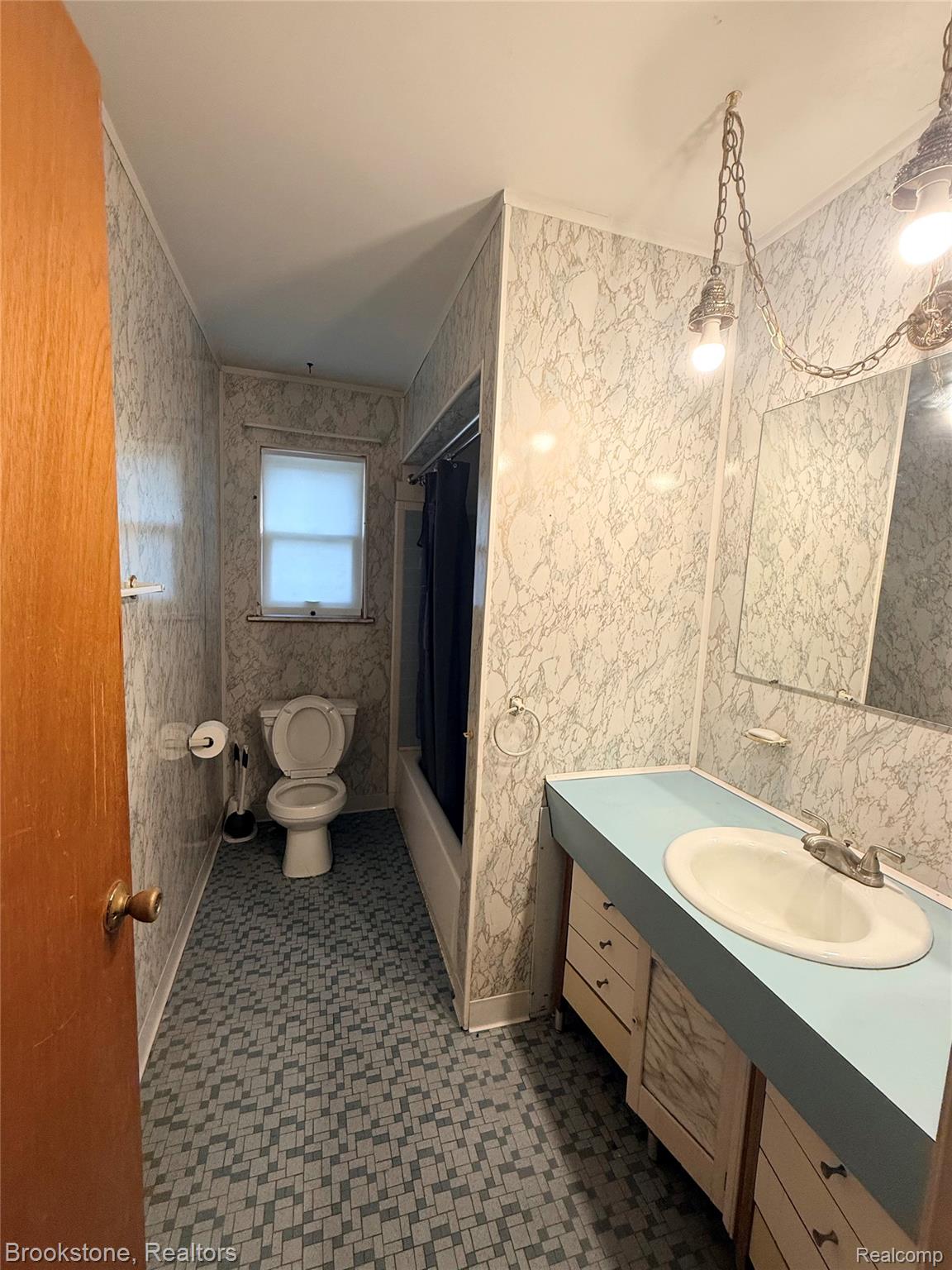 14144 Martin Road Warren, MI 48088 - Photo 7 of 10 Bathroom featuring a vanity with an integrated sink, patterned floor tiles, and a window