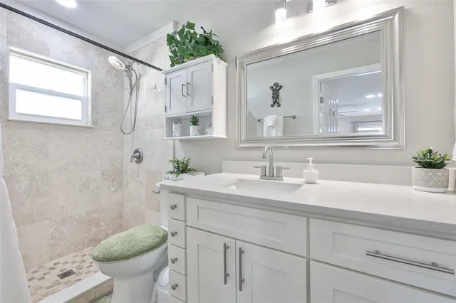 a bedroom with a bed and a flat tv screen on dresser