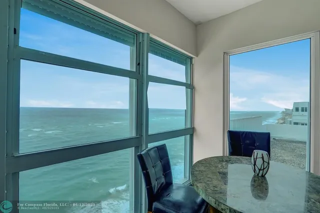 a dining room with wooden floor a chandelier a glass table and chairs