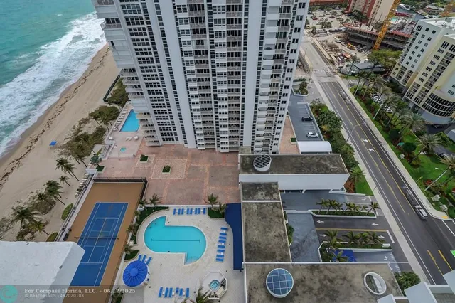 a hallway with painting on the wall and a potted plant