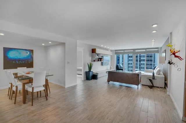 a living room with stainless steel appliances furniture and a flat screen tv