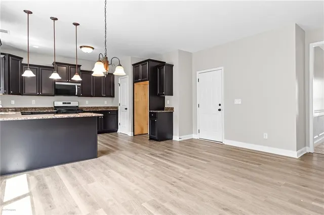 a kitchen with stainless steel appliances granite countertop a sink a stove and a refrigerator