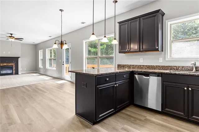 a kitchen with granite countertop a stove a sink and a wooden floor
