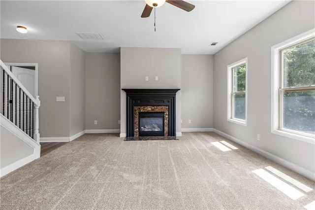 a view of an empty room with window and fire place
