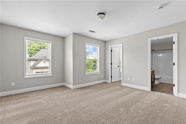 a view of an empty room with window and closet area