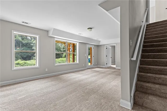 a view of an empty room with wooden floor and windows