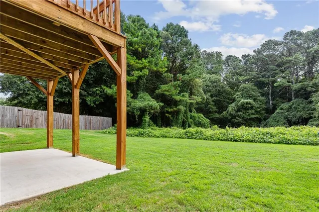 a view of a backyard with table and chairs under an umbrella
