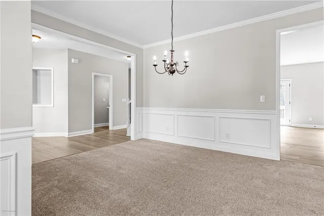 an empty room with chandelier and glass door