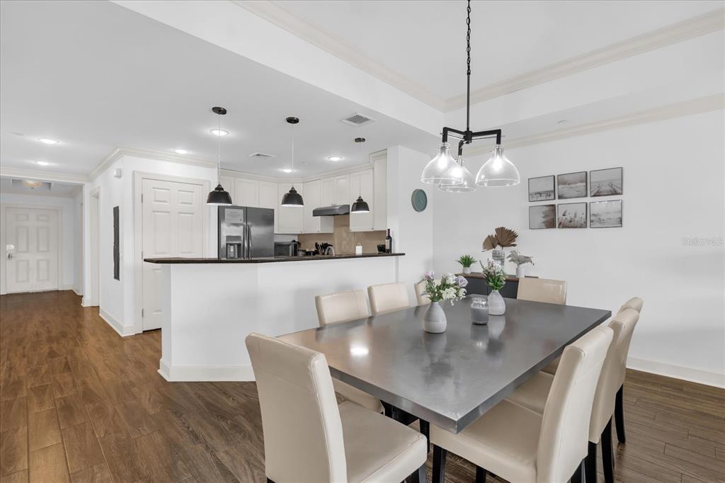 1362 Centre Ct Ridge Drive, Unit 102 Reunion, FL 34747 - Photo 4 of 35 a dining room with kitchen island a table and chairs