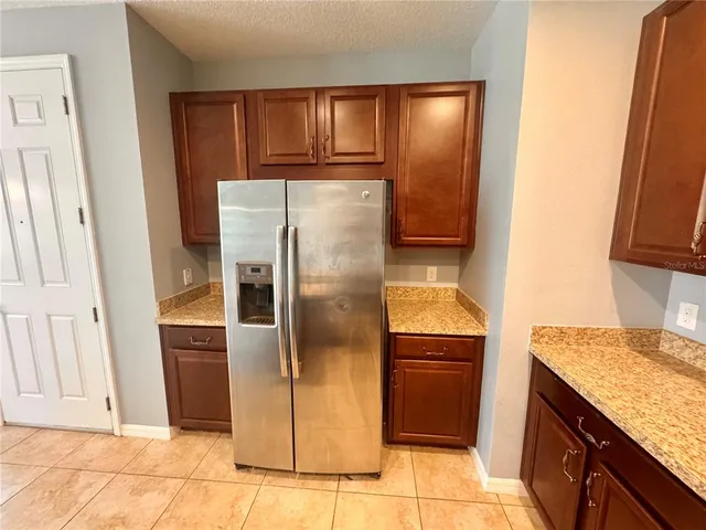 a kitchen with a refrigerator sink and cabinets