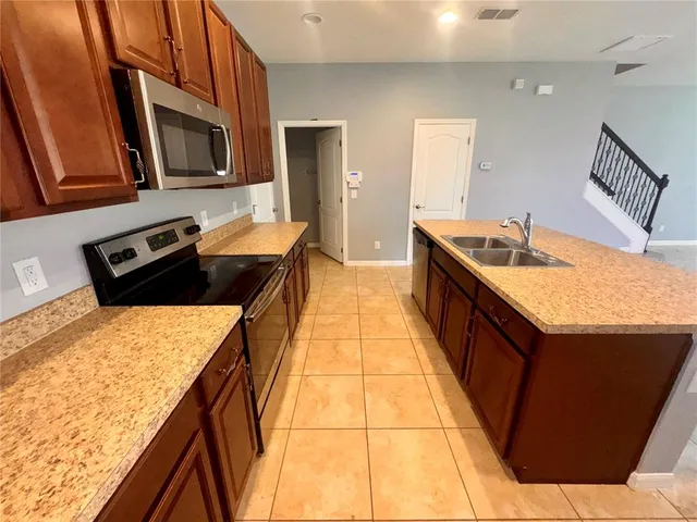 a kitchen with stainless steel appliances granite countertop a sink stove and microwave