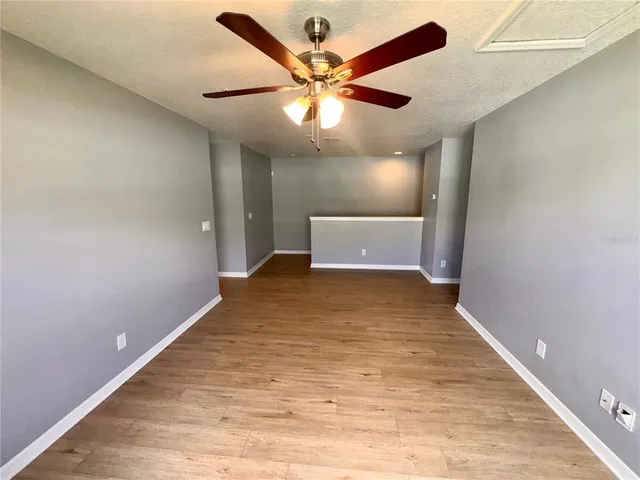 a view of a big room with wooden floor and a ceiling fan