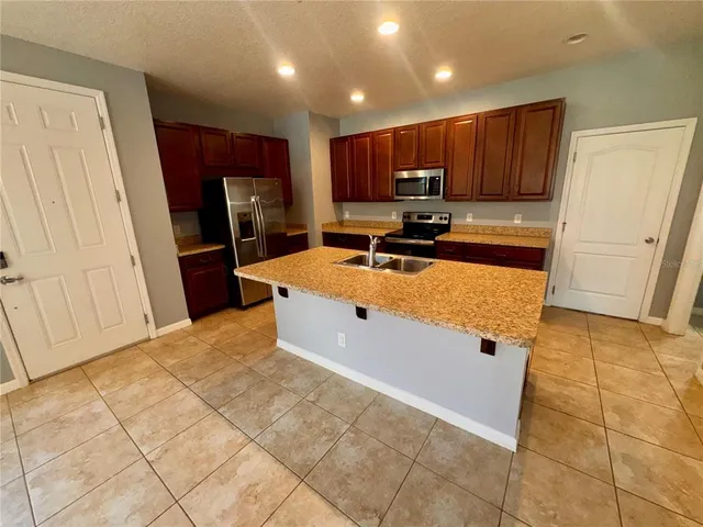 a kitchen with stainless steel appliances a refrigerator sink stove microwave and cabinets