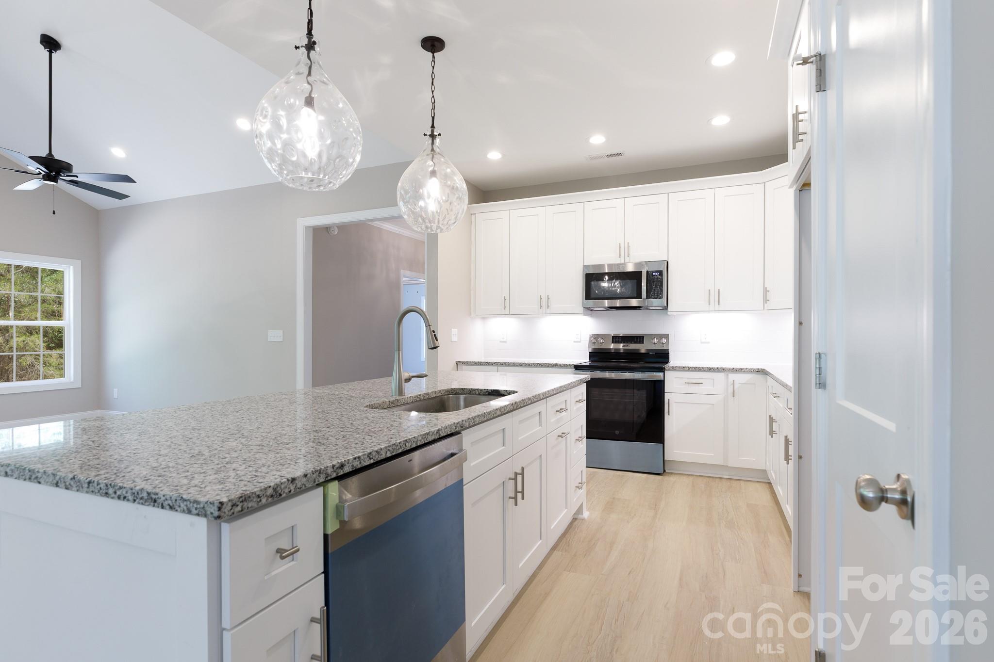 2902 Peden Bridge Road Chester, SC 29706 - Photo 7 of 44 a kitchen with a sink stainless steel appliances and chandelier