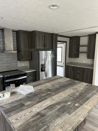 a kitchen with stainless steel appliances wooden floor a refrigerator and a stove