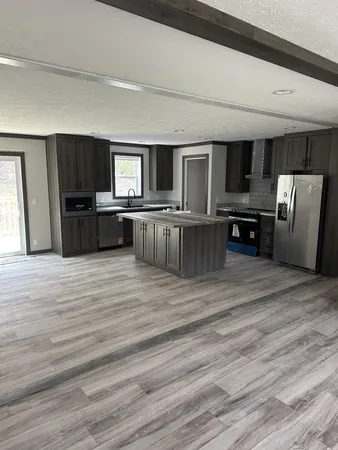a large kitchen with stainless steel appliances wooden floors and wooden cabinets