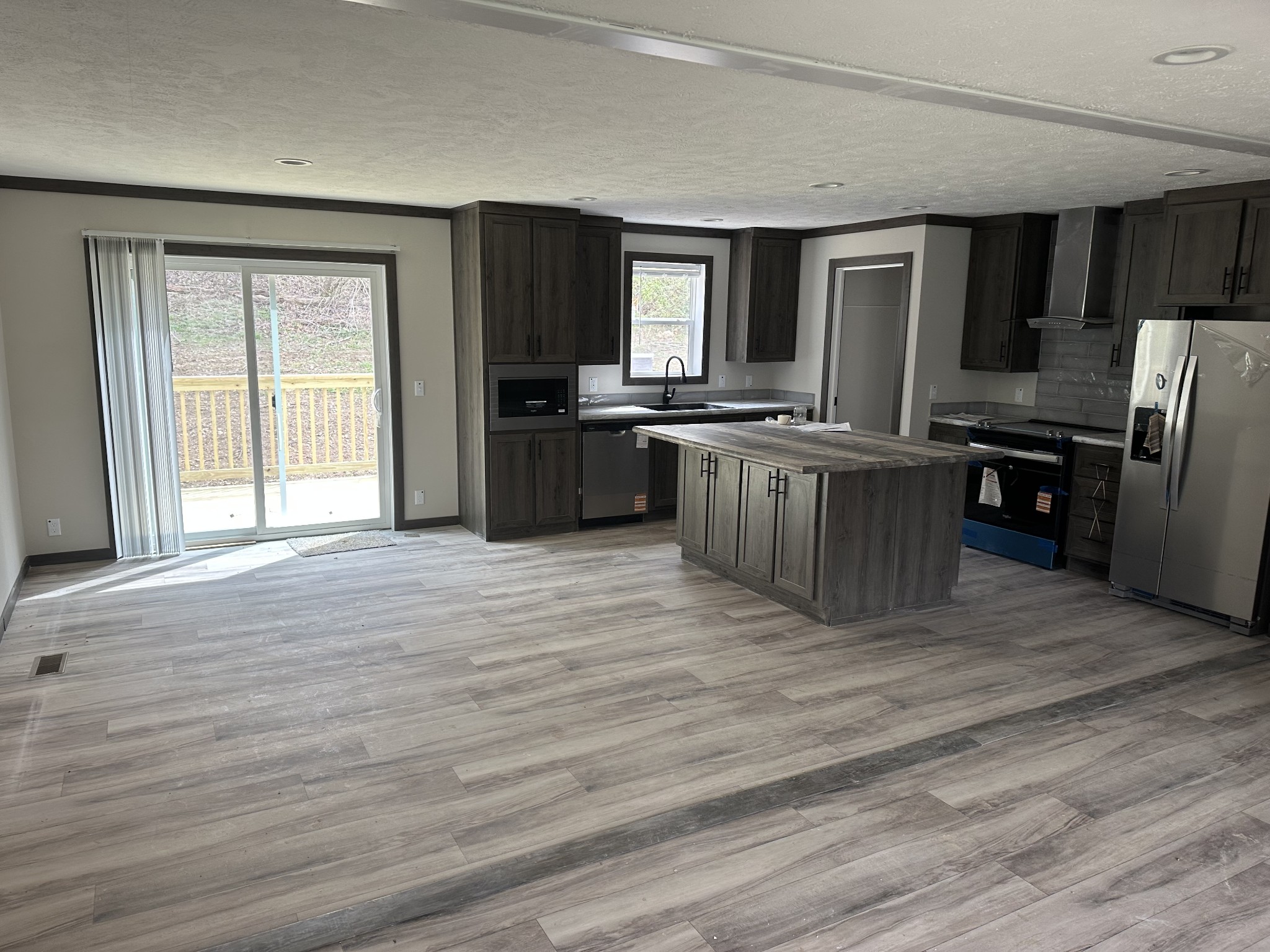 3340 Wixtown Road Westmoreland, TN 37186 - Photo 20 of 27 a large kitchen with stainless steel appliances wooden floors and wooden cabinets