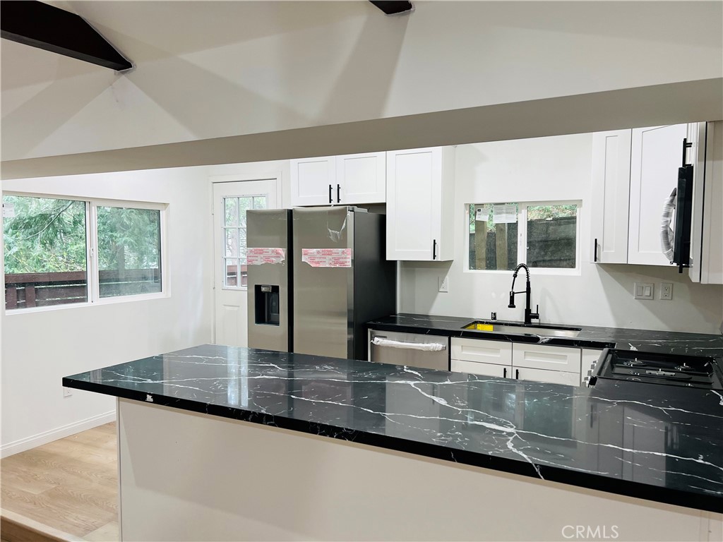 23817 Crest Forest Drive Crestline, CA 92325 - Photo 4 of 9 a kitchen with stainless steel appliances granite countertop a sink a stove and a microwave