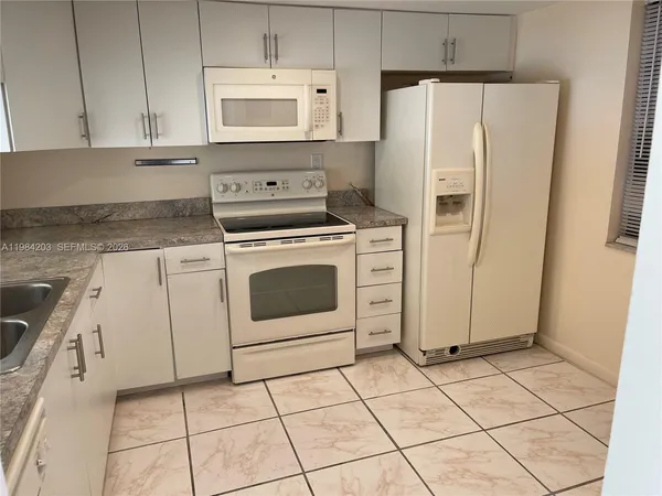 a kitchen with cabinets and white appliances
