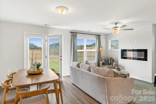 a living room with furniture a flat screen tv and a large window