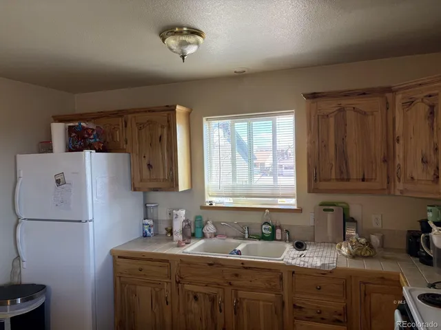 a kitchen with a sink a refrigerator and cabinets