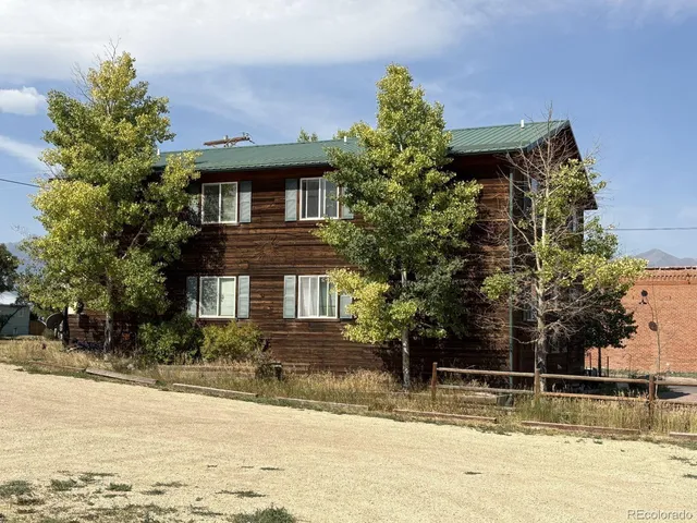 a front view of a house with a yard and trees